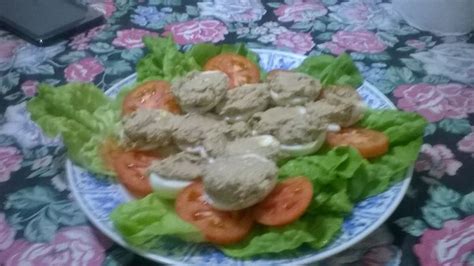 A Plate Filled With Lettuce And Tomatoes On Top Of A Floral Table Cloth