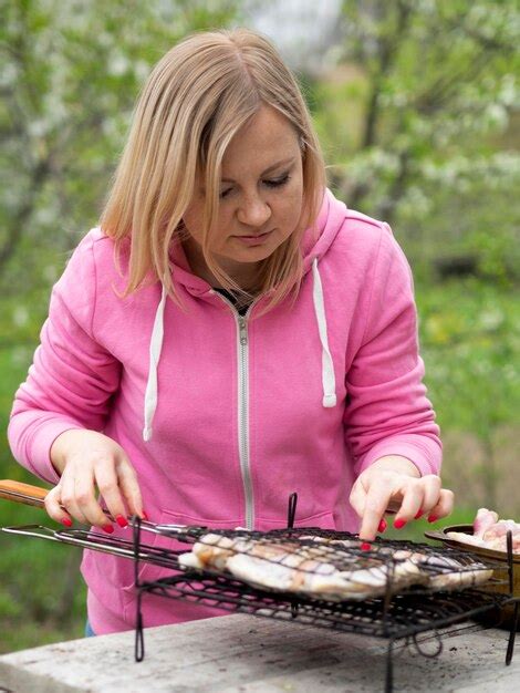 Premium Photo | Woman preparing food on barbecue outdoors