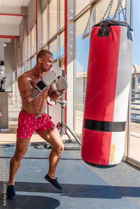 Side View Of Concentrated Male Boxer With Naked Torso And In Gloves