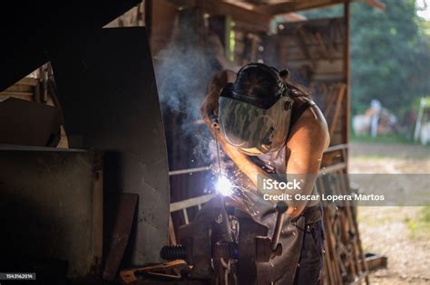 Herrero Soldando Un Trozo De Hierro En El Taller De Su Casa Foto De