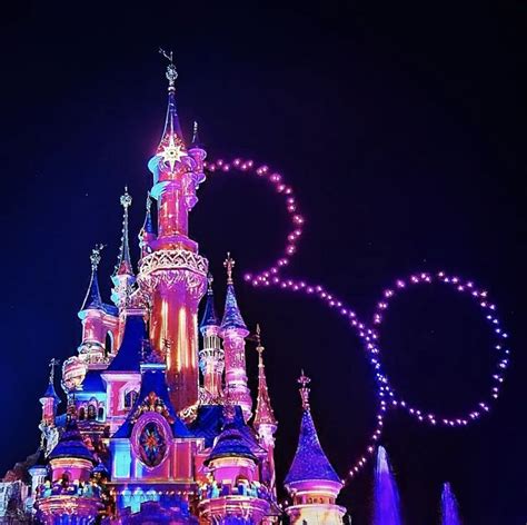 The Disneyland Castle Is Lit Up At Night With Lights And Decorations On