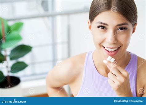 smile young woman eating white chewing gum stock photo image  woman