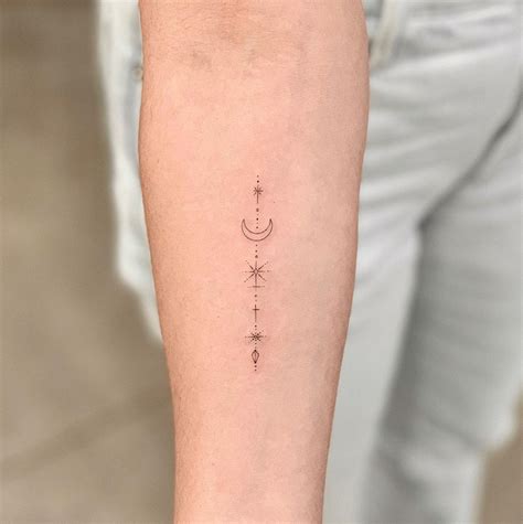 A Woman S Arm With A Small Star And Moon Tattoo On The Left Forearm