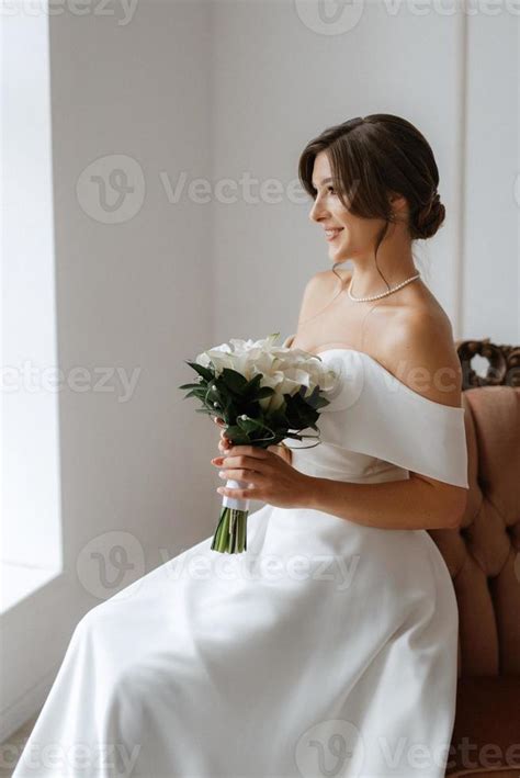 Brunette Bride In A Tight Wedding Dress In A Bright Studio Stock Photo At Vecteezy