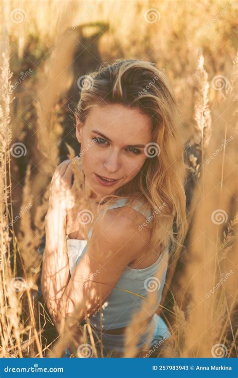 Beautiful Blonde Woman On A Walk In A Field With Dry Grass A Walk In