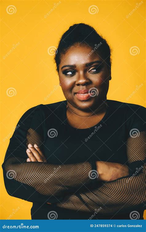 Portrait Of A Beautiful Black Woman Smiling With Crossed Arms On Yellow