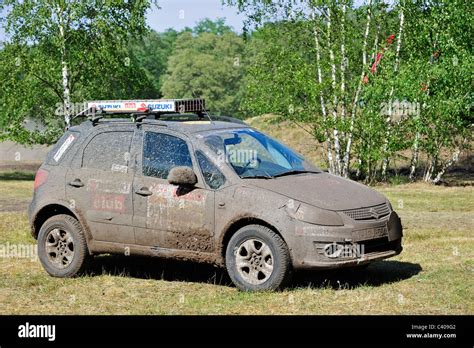 Suzuki SX4 four-wheel drive off-road vehicle covered in mud after rally cross-country racing ...