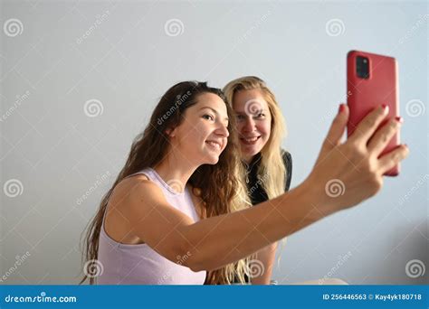 Young Smilling Women Making Selfie On The Light Room Portrait Of Two