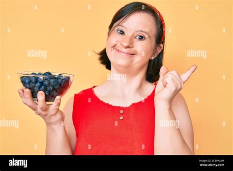 Brunette Woman With Down Syndrome Holding Blueberries Smiling Happy