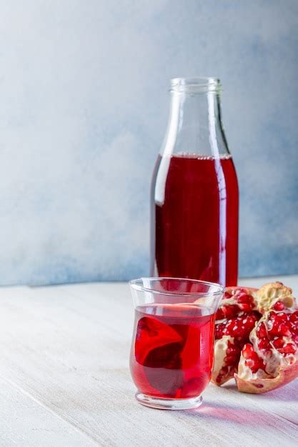 Botella Con Jugo De Granada Y Un Vaso Granada Madura Entera Y Pelada