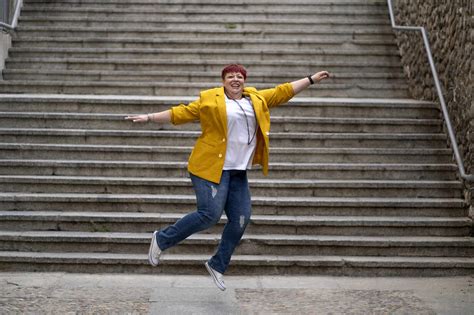 Carefree Mature Woman Jumping In Front Of Steps Stock Photo