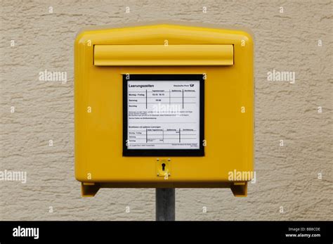 Yellow Mail Box Of The German Post Office In Front Of A Roughcast Wall