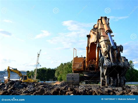 Excavator With Hydraulic Shears Breaks Asphalt On A Construction Site