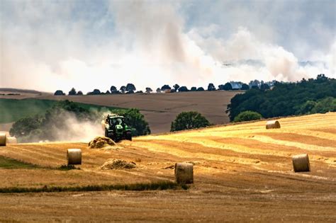 Premium Photo Tractor Harvesting A Field And Making Straw Bales At