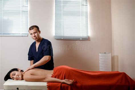 A Young Woman Gets A Massage Procedure Masseur Makes Back Massage