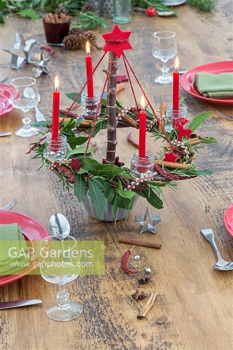 Red Themed Advent Candle Holder With Lit Candles As Centrepiece In A