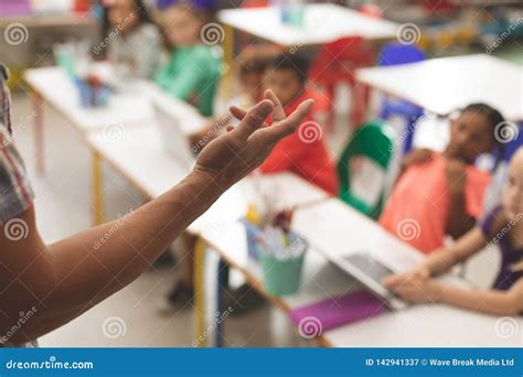 Close-up of Teacher Arm Against Blur School Kids Sitting on Their Chair Stock Image - Image of ...