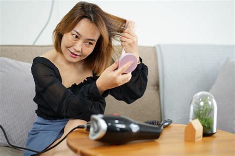 Beautiful Asian Woman Comb Her Hair After Drying Hair In The Living