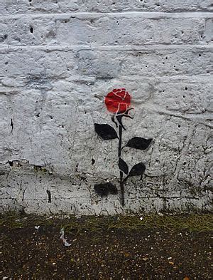 A Red Rose Painted On The Side Of A White Brick Wall