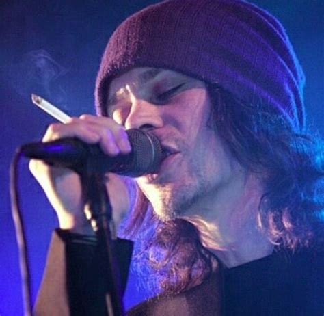 A Man In A Beanie Singing Into A Microphone