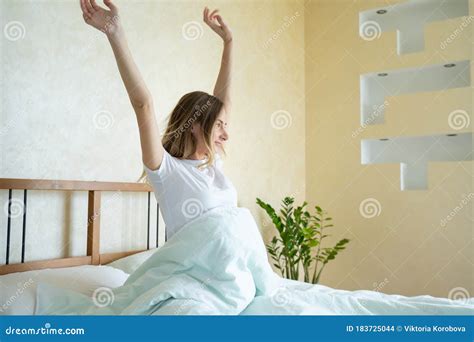 Woman Waking Up In Her Bed Fully Rested Woman Stretching In Bed After