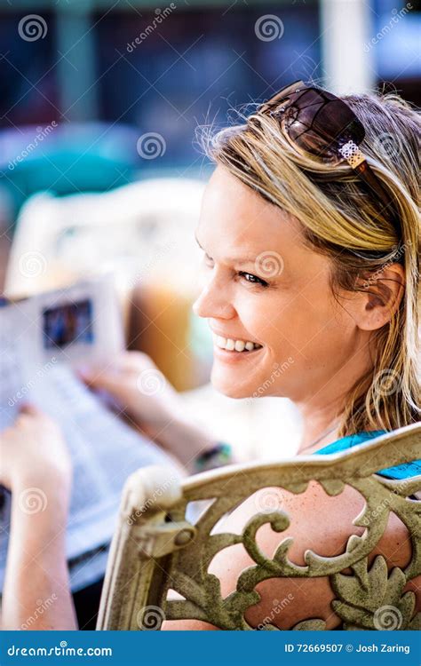 Smiling Blonde Woman Reading Newspaper Outdoors Stock Image Image Of