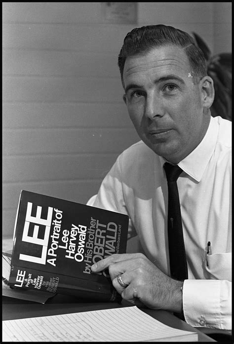 Photograph Of Robert Oswald Holding His Book About His Brother Lee