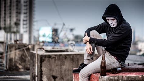 Mystery Man In The Mask Sitting With Empty And Broken Bottle Stock