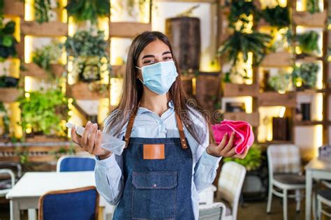 Portrait Of Attractive Female Waitress Wearing Face Mask Holding A