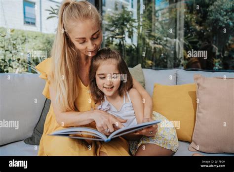 Zwei Kinder Sitzen Auf Einer Couch Und Lesen Ein Buch Fotos Und