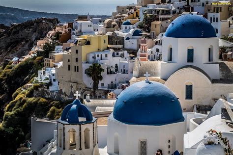 Tapety zdjęcia Domy Niebieskie Grecja Wioska Oia Santorini Dachy