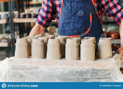 Male Potter Hands Holding Tray With Ceramic Pots In The Pottery Stock