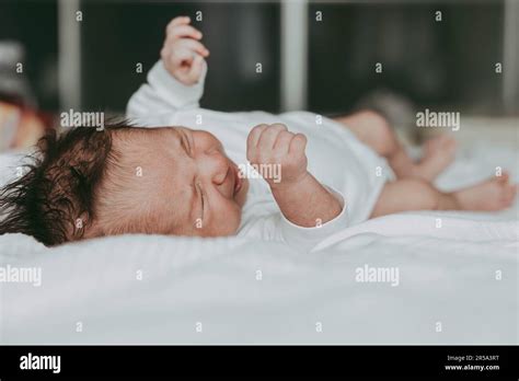 Newborn Lies On The Bed And Cries Stock Photo Alamy