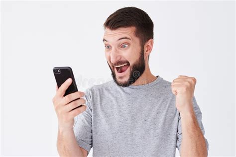 Homem Novo Entusiasmado Que Grita Em Seu Telefone Celular Foto De Stock