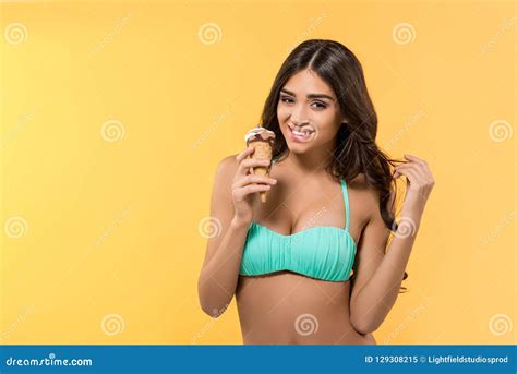 Muchacha Sonriente Hermosa Que Presenta En Bikini Con El Cono De Helado Imagen De Archivo