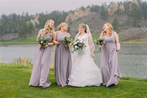 A Bride And Her Four Bridesmaids Laughing Together In Front Of The Lake