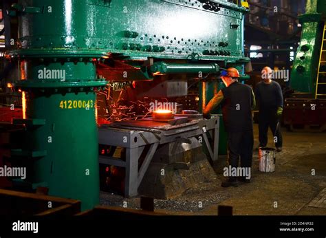Blacksmith Processes The Red Hot Iron Under A Huge Press Metal Forging Stamping Under Hammer