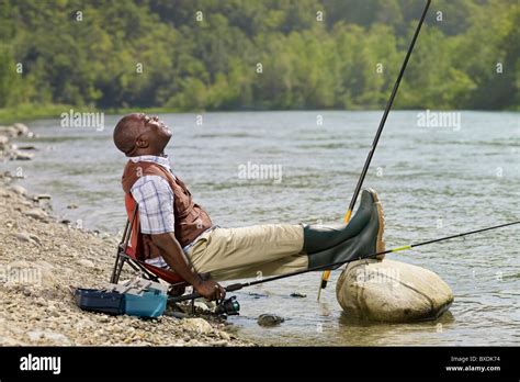Black Man With Feet Up Fishing In Stream Stock Photo Alamy