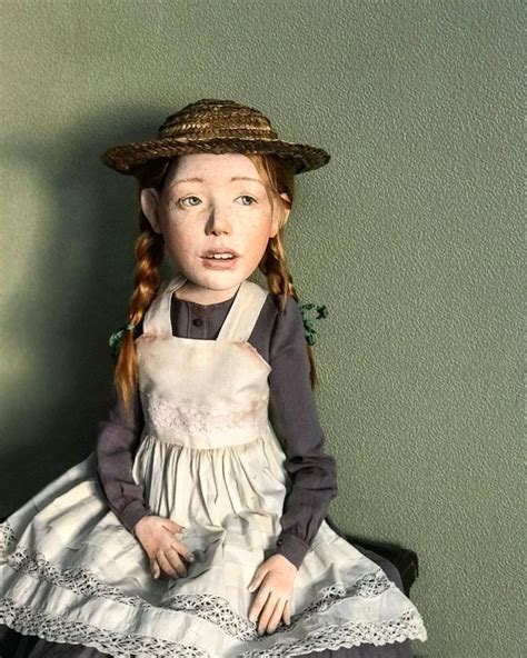 A Doll Sitting On Top Of A Chair Wearing A Dress And Hat With Long Red Hair