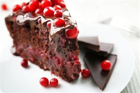 Premium Photo Piece Of Chocolate Cake With Cranberries On Plate Closeup