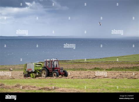 Farmer Baling Round Bales Of Hay With A Vintage International Tractor