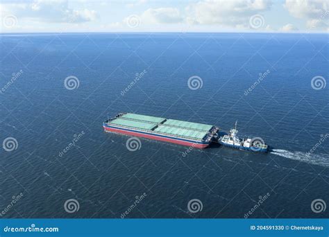 Tugboat Pulling Barge With Cargo By Water Aerial View Stock Photo