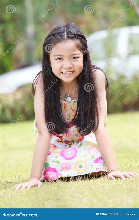 Face Of Asian Girl With Long Hair Sitting On Green Grass Field Stock