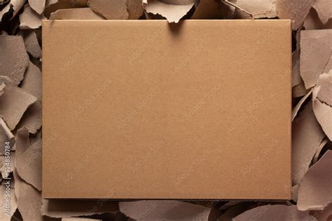 Cardboard Box On Torn Paper Background Texture Recycling Concept And