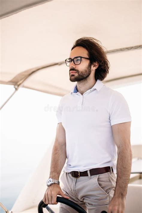 Young Handsome Bearded Sailor Man Driving His Motor Boat Stock Image