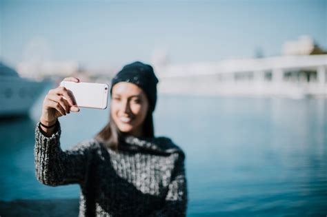 Femme Souriante Prenant Selfie Avec De L eau En Arrière plan Photo