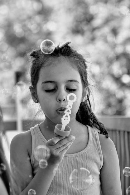 Premium Photo Cute Girl Blowing Bubbles Outdoors