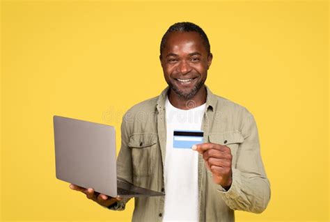 Glad Mature Black Guy In Casual Using Computer And Credit Card