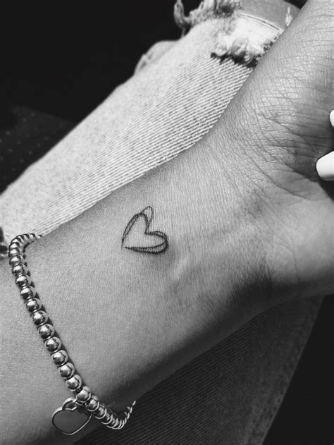 A Woman S Arm With A Small Heart Tattoo On The Left Side Of Her Wrist