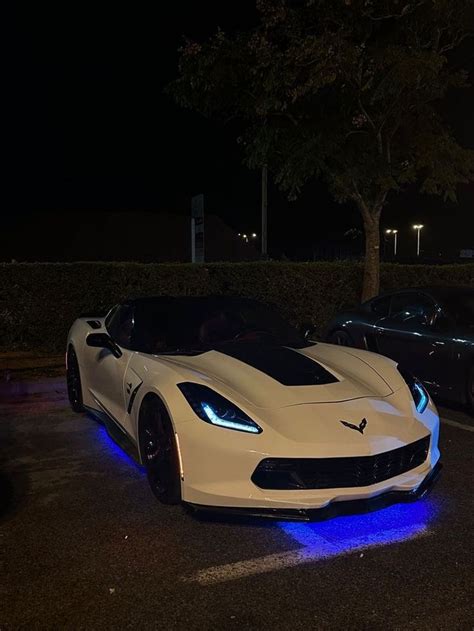 Two White Sports Cars Parked Next To Each Other In A Parking Lot With